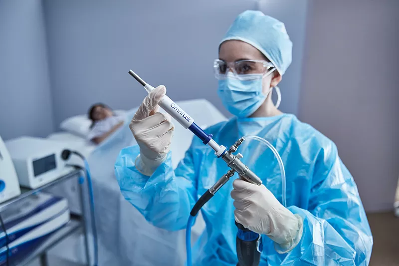 Healthcare provider holding medical device in lab setting.